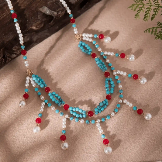 Close - up view of the double - layer turquoise Yiluo necklace, highlighting the details of the turquoise beads, red accent beads, and small pearl pendants.