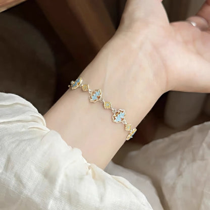  Enamel lotus bracelet worn on wrist, emphasizing blue and gold lotus pattern.
