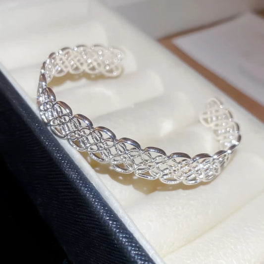 Silver flower hollow - out open bracelet isolated in a box.