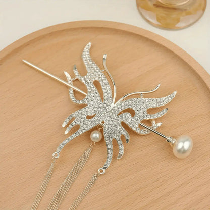 Gold-tone full rhinestone butterfly hair accessory set with long thin chain tassels, presented on wooden plate to highlight bright gold metal finish and crystal sparkle.