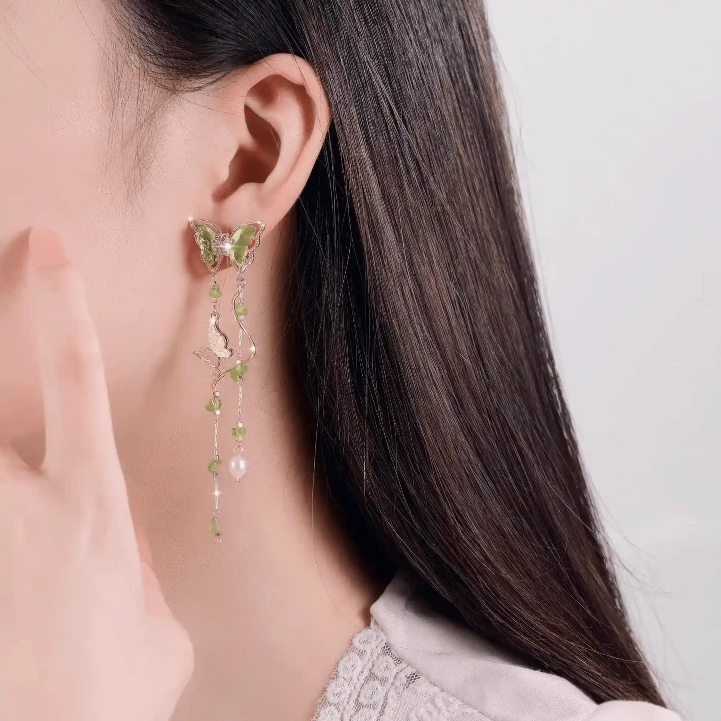 Green Wild Tea Butterfly Tassel Earrings worn on a person's ear, highlighting the elegant tassel design.