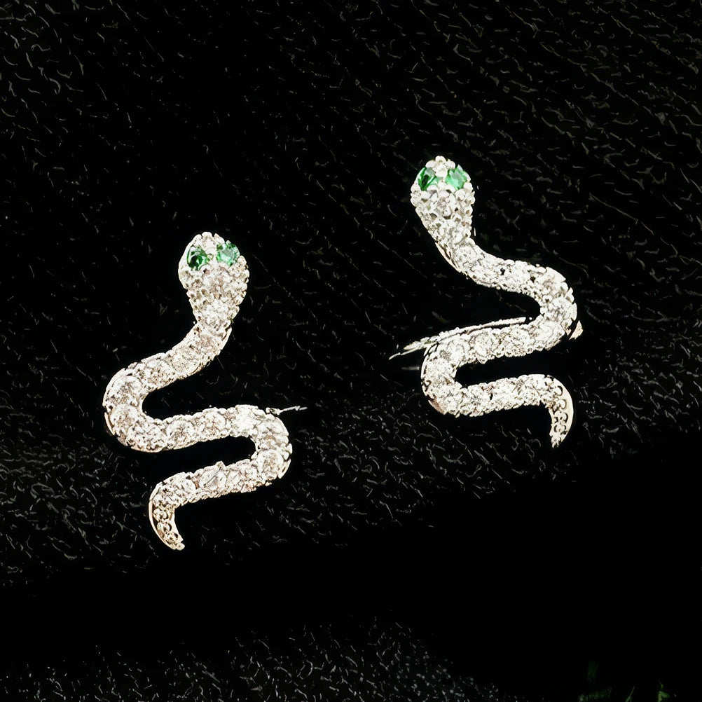 Green zircon snake - shaped stackable ear cuff isolated on black background.