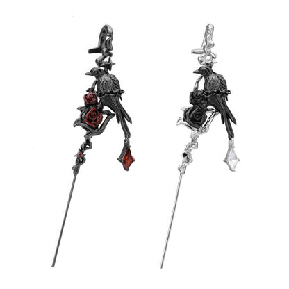 Pair of impression crow ear cuffs isolated on white background, with dark and silver - toned designs.