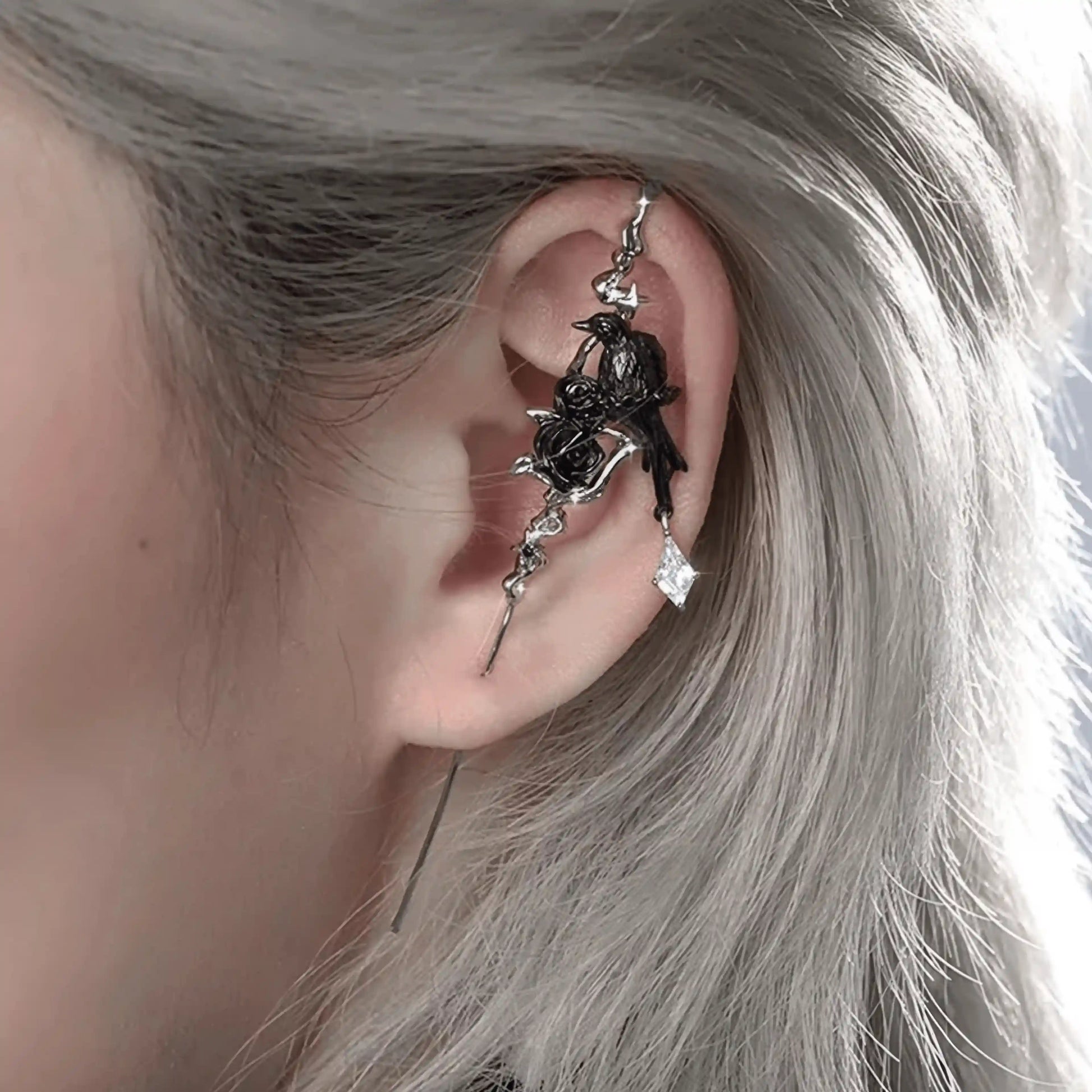Impression crow ear cuff worn on ear, showcasing the detailed crow and dark metal elements.