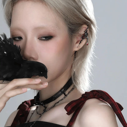  Impression crow ear cuff worn on ear, paired with a dark - toned outfit and necklace.