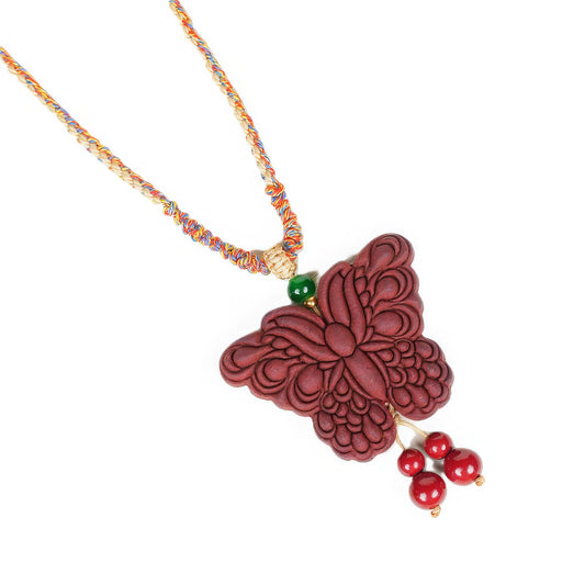  Another angle full view of the Lady Huarui - Double-Sided Butterfly Incense Pendant, highlighting the detailed carvings on the red butterfly and the attached colorful cord with a green bead and red hanging beads.