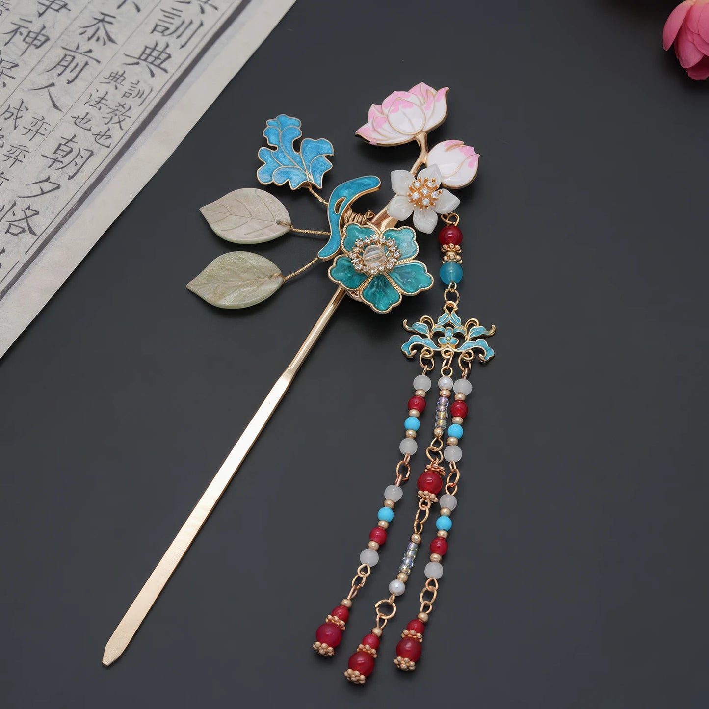 Side view of the hairpin, highlighting the gold-toned pin base, layered floral design, and the intricate beaded tassel structure.