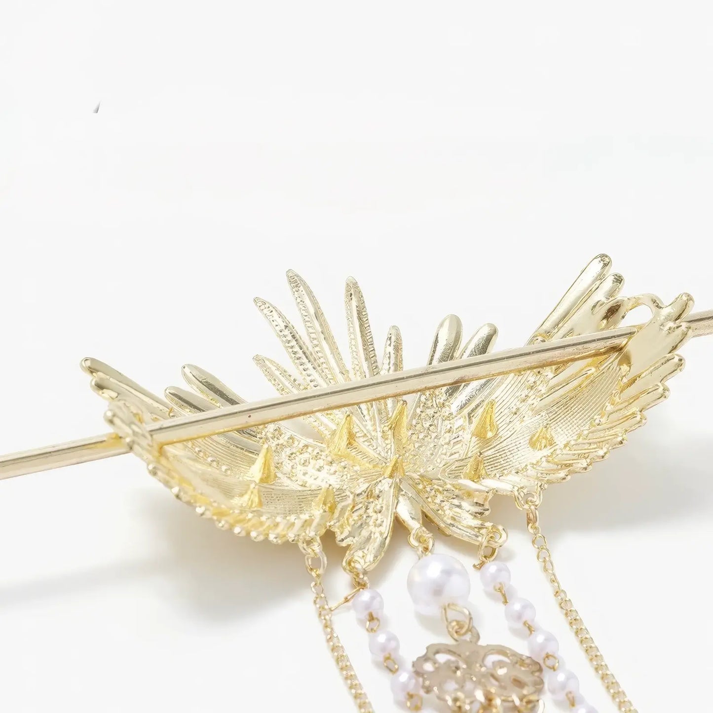 Close-up shot of the hairpin's wing metal texture, pearl beadwork and tassel structure, showcasing exquisite embossing and inlay craftsmanship.