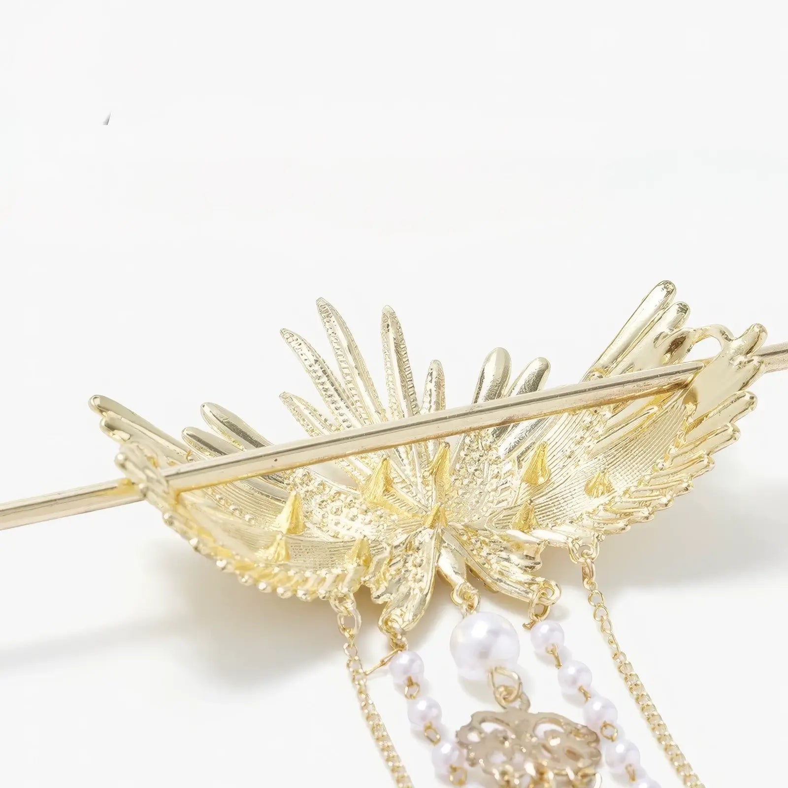 Close-up shot of the hairpin's wing metal texture, pearl beadwork and tassel structure, showcasing exquisite embossing and inlay craftsmanship.