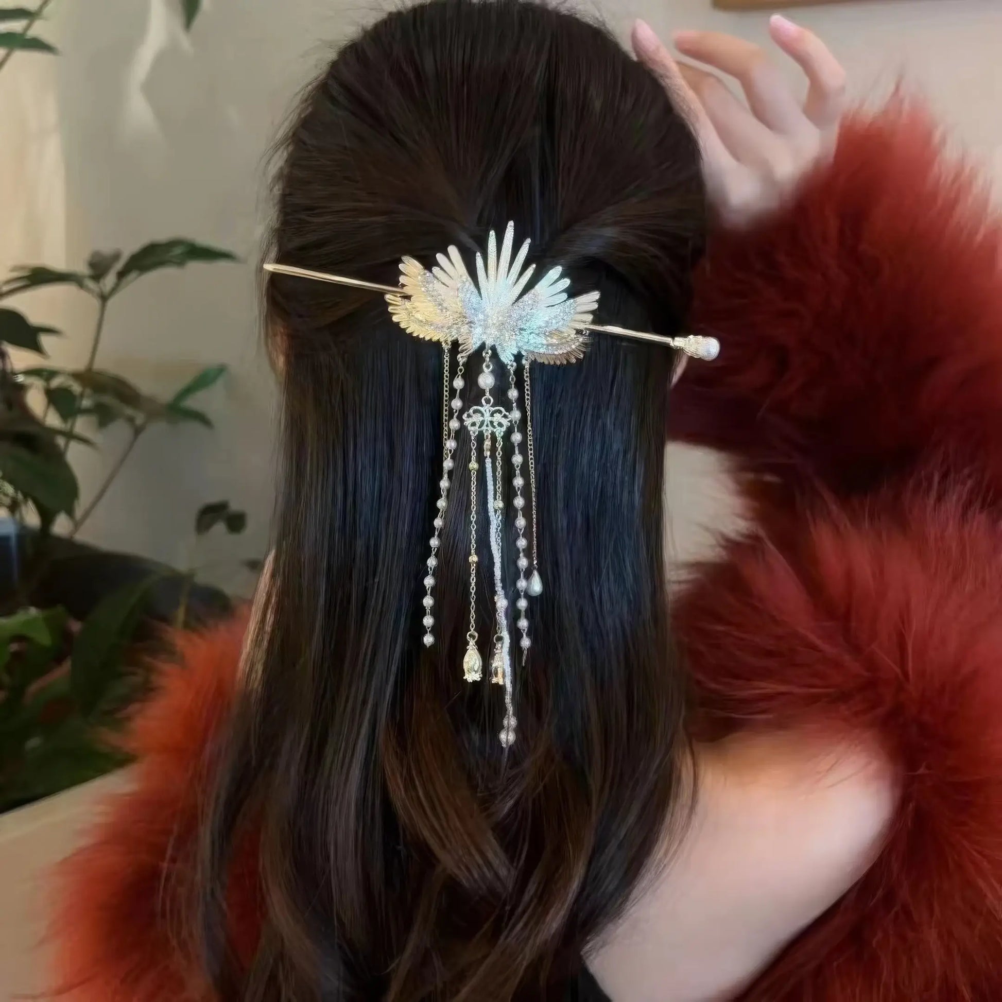 Back shot of medium-length dark hair styled half-up with angel wing pearl tassel hairpin, paired with red fur coat for gentle fancy aesthetic.