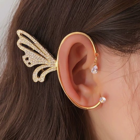 Gold metal diamond - inlaid butterfly ear cuff worn on ear, showcasing luxurious diamond details.