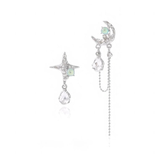 Moon and star asymmetric zircon earrings isolated on white background, highlighting the unique design of each earring.