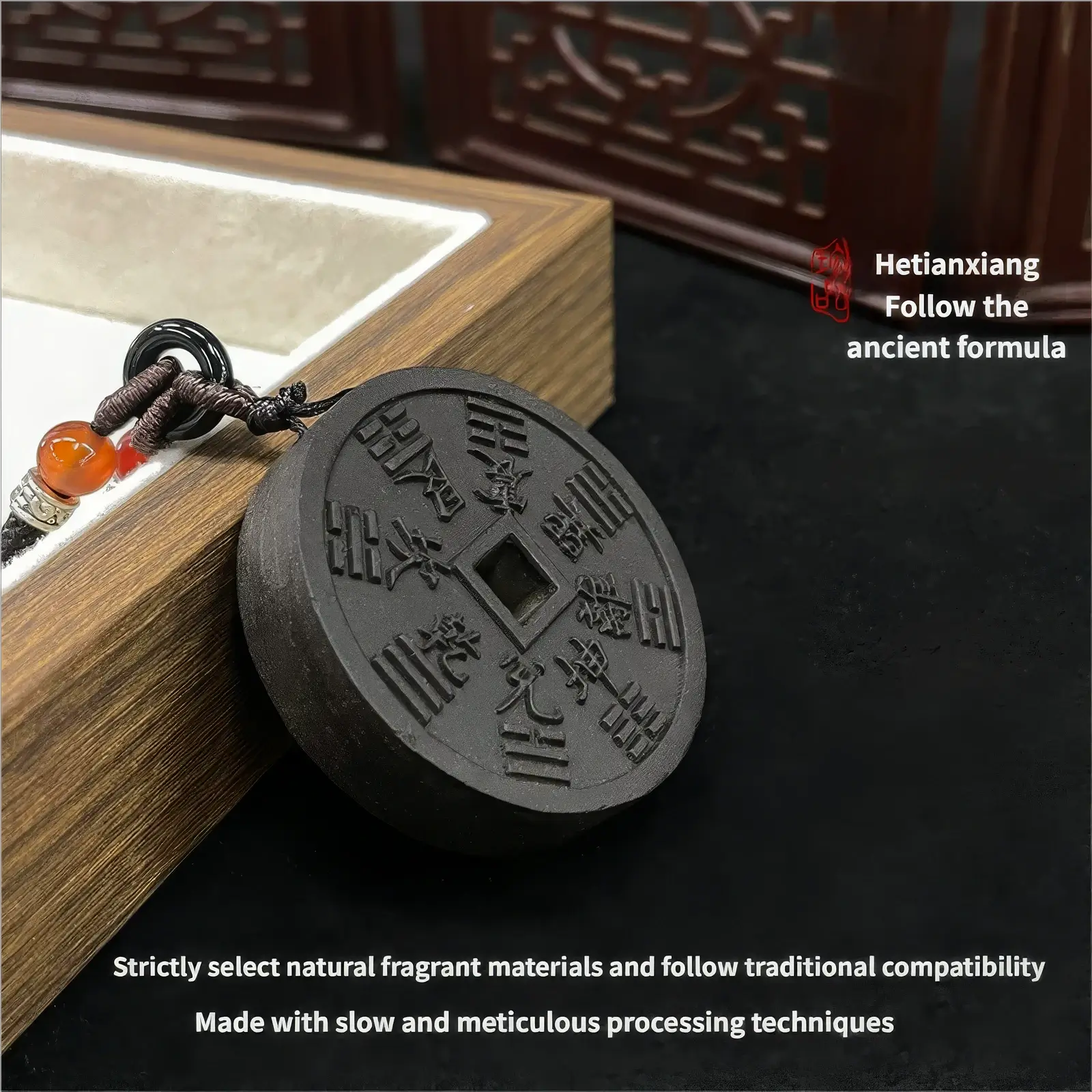 Mountain Ghost Amulet incense pendant placed beside a wooden box, with text stating "Hetianxiang - Follow the ancient formula" and "Strictly select natural fragrant materials and follow traditional compatibility. Made with slow and meticulous processing techniques".