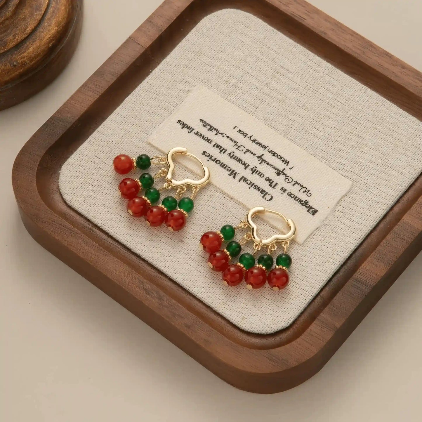 Neo - Chinese palace - style beaded earrings displayed on a cushioned tray, emphasizing the intricate and stylish red and green bead design.