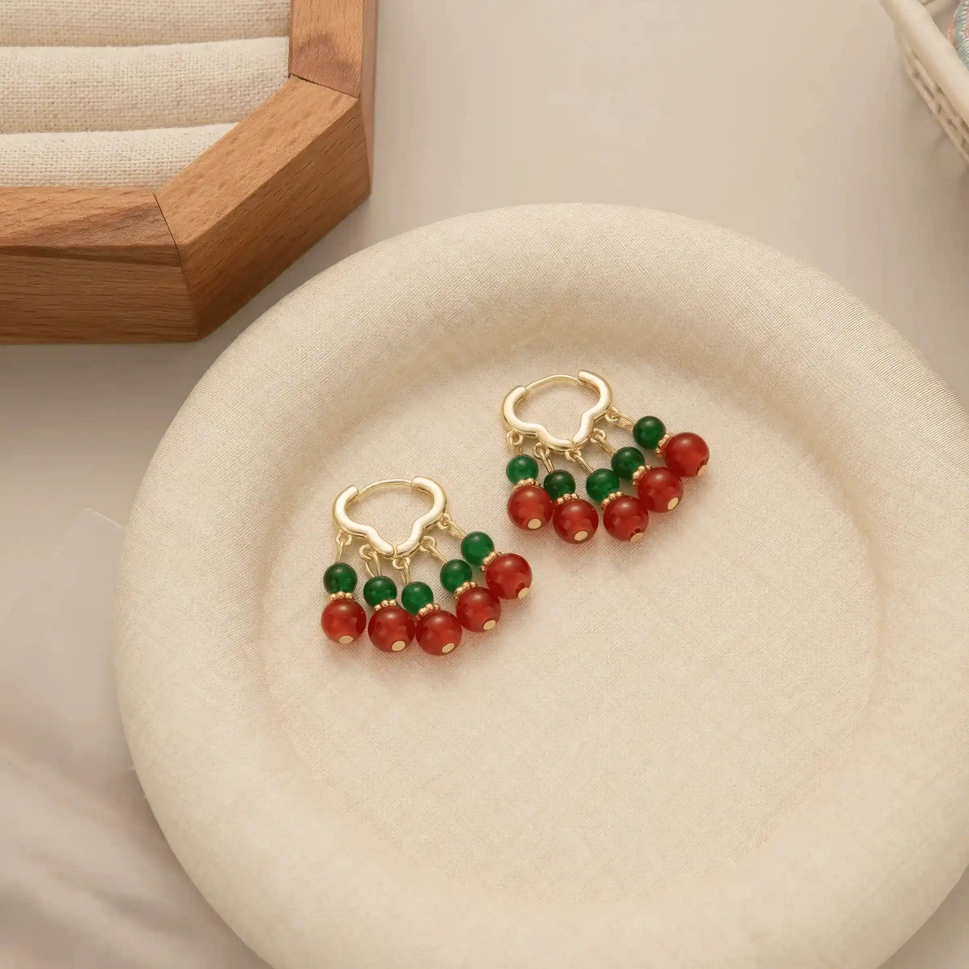 Neo - Chinese palace - style beaded earrings displayed on a white plate, showcasing the elegant red and green bead structure.