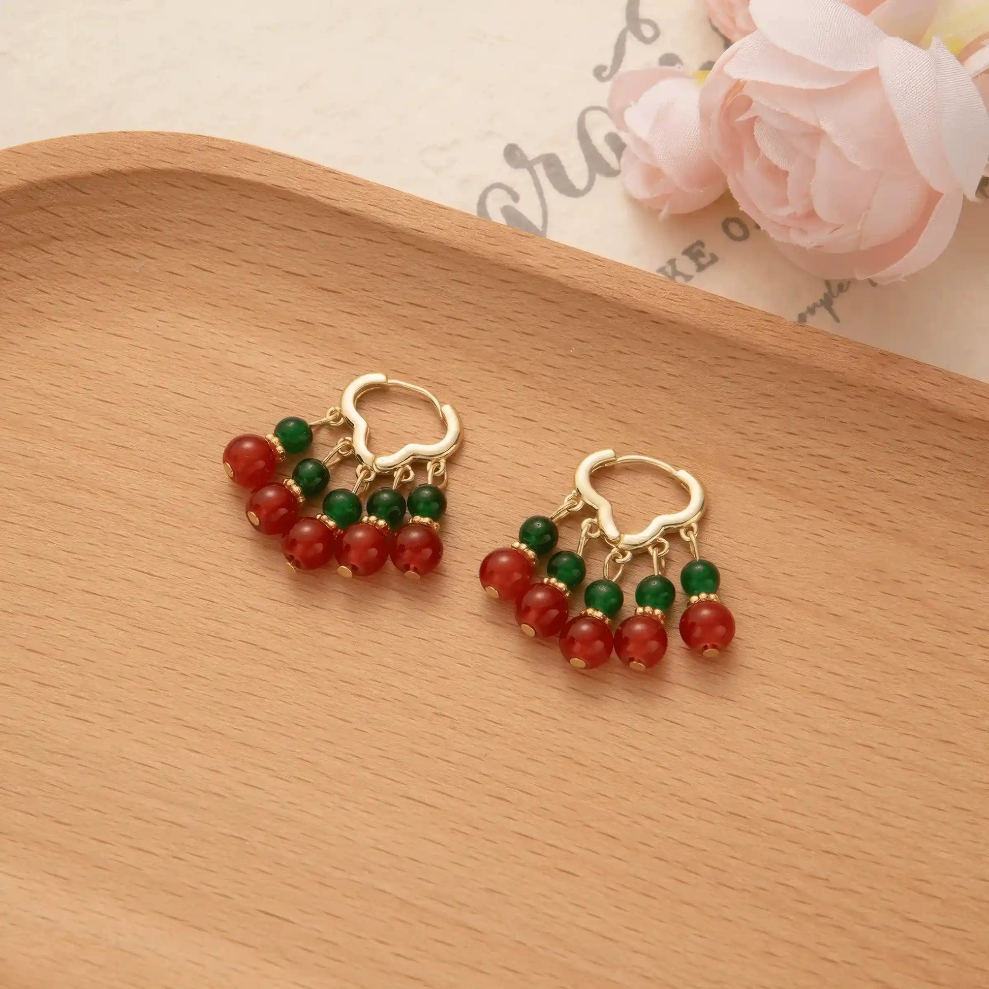 Neo - Chinese palace - style beaded earrings displayed on a wooden tray, emphasizing the intricate red and green bead arrangement.
