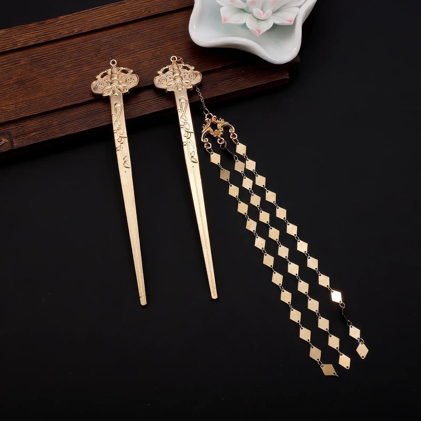 New Chinese - style rhombus - shaped hairpin with tassels placed on a black surface, next to a decorative white object.