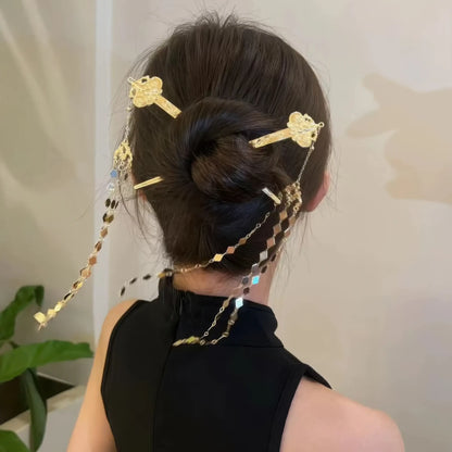 New Chinese - style rhombus - shaped hairpin with tassels styled in a bun, viewed from the back with a black - sleeveless top.