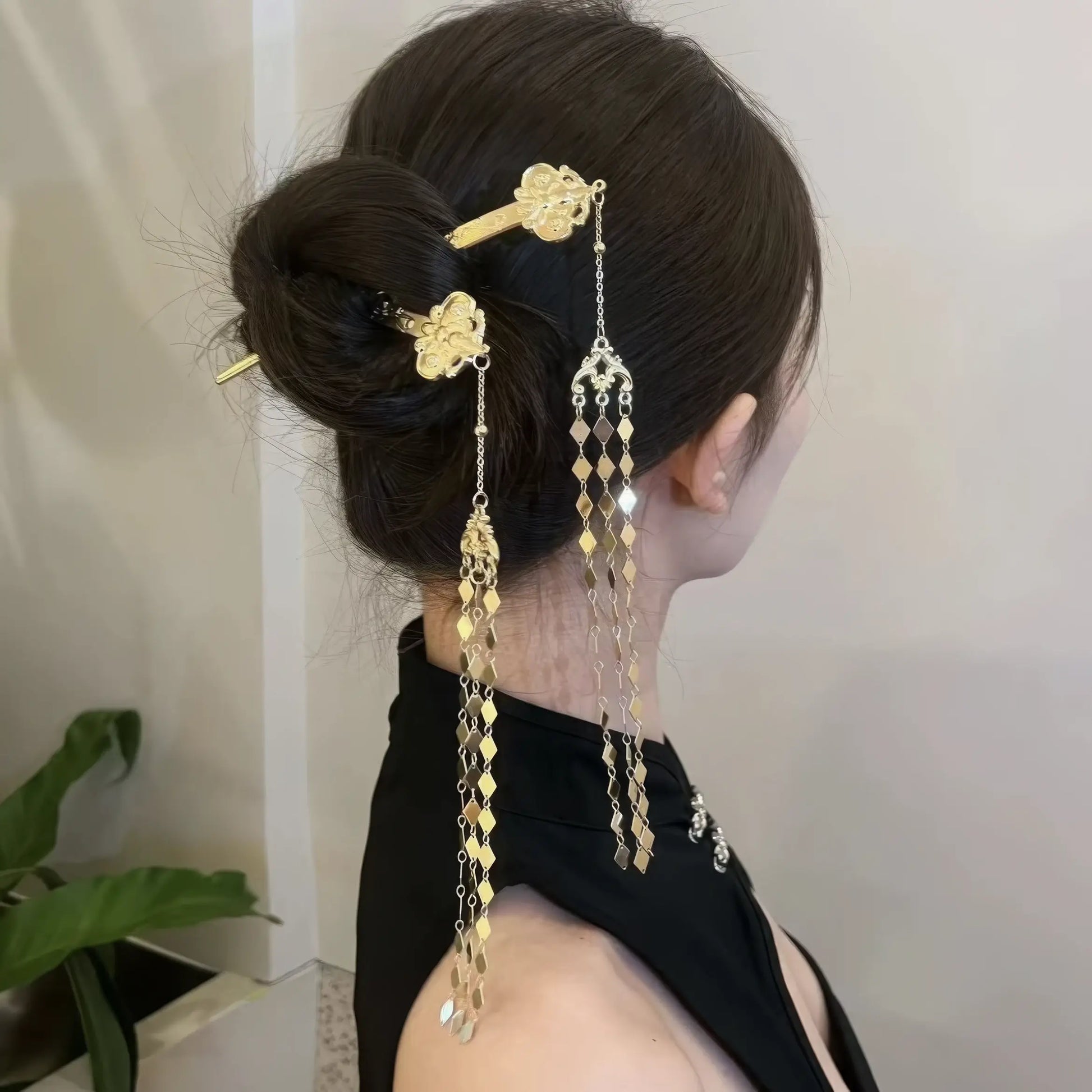  Another view of the new Chinese - style rhombus - shaped hairpin with tassels worn in a bun, from a side - back angle.