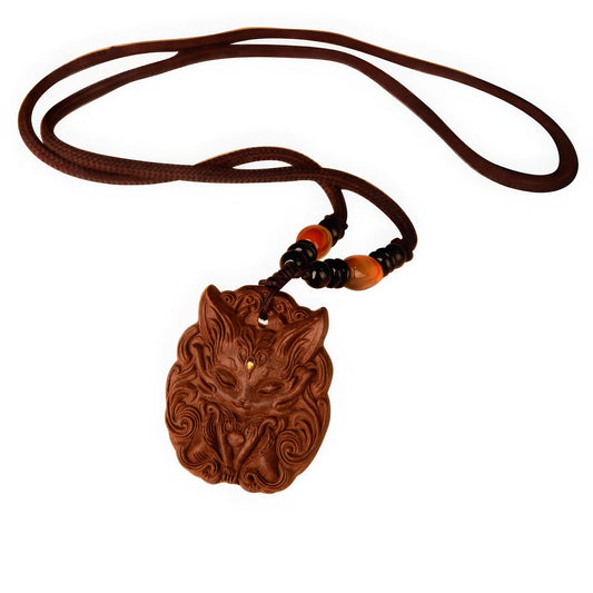 Full view of a nine - tailed fox incense pendant on a simple brown cord, highlighting the overall shape and the carved fox face.