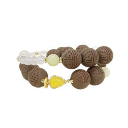 Full - view of the Poria Cocos Chinese medicine bracelet, featuring brown patterned beads, white crystal beads, a light - yellow jade bead, and a yellow inlaid gourd - shaped bead.