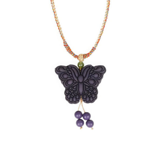 Front angle view of the "Purple Qi Coming from the East - Double-Sided Butterfly Incense Pendant," with exquisite and intricate patterns carved on the butterfly’s wings, a colorful lanyard attached to the top, and a green bead at the lanyard’s end.