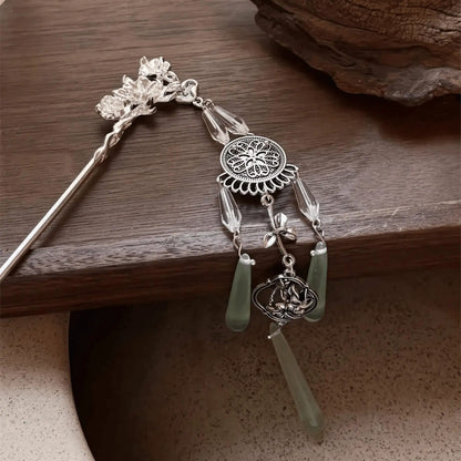 An angled view of the retro silver wind chime hairpin displayed on a dark wooden surface, emphasizing the three-dimensional structure of the tassels and metalwork.