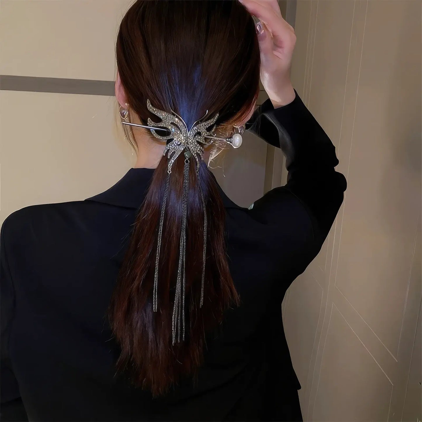 Silver rhinestone butterfly hair accessory set decorating long low ponytail, delicate long tassels create soft flowing silhouette.