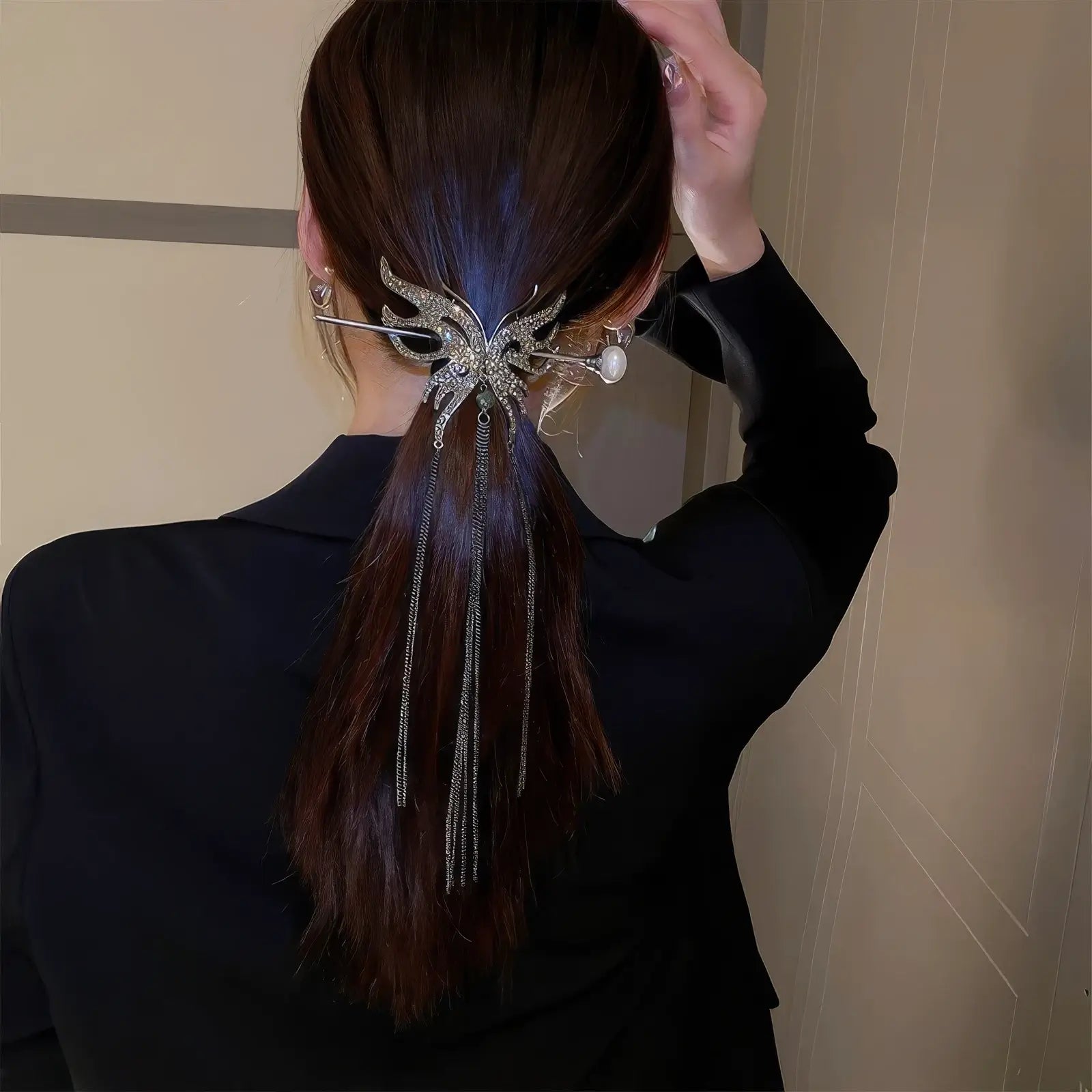 Silver rhinestone butterfly hair accessory set decorating long low ponytail, delicate long tassels create soft flowing silhouette.