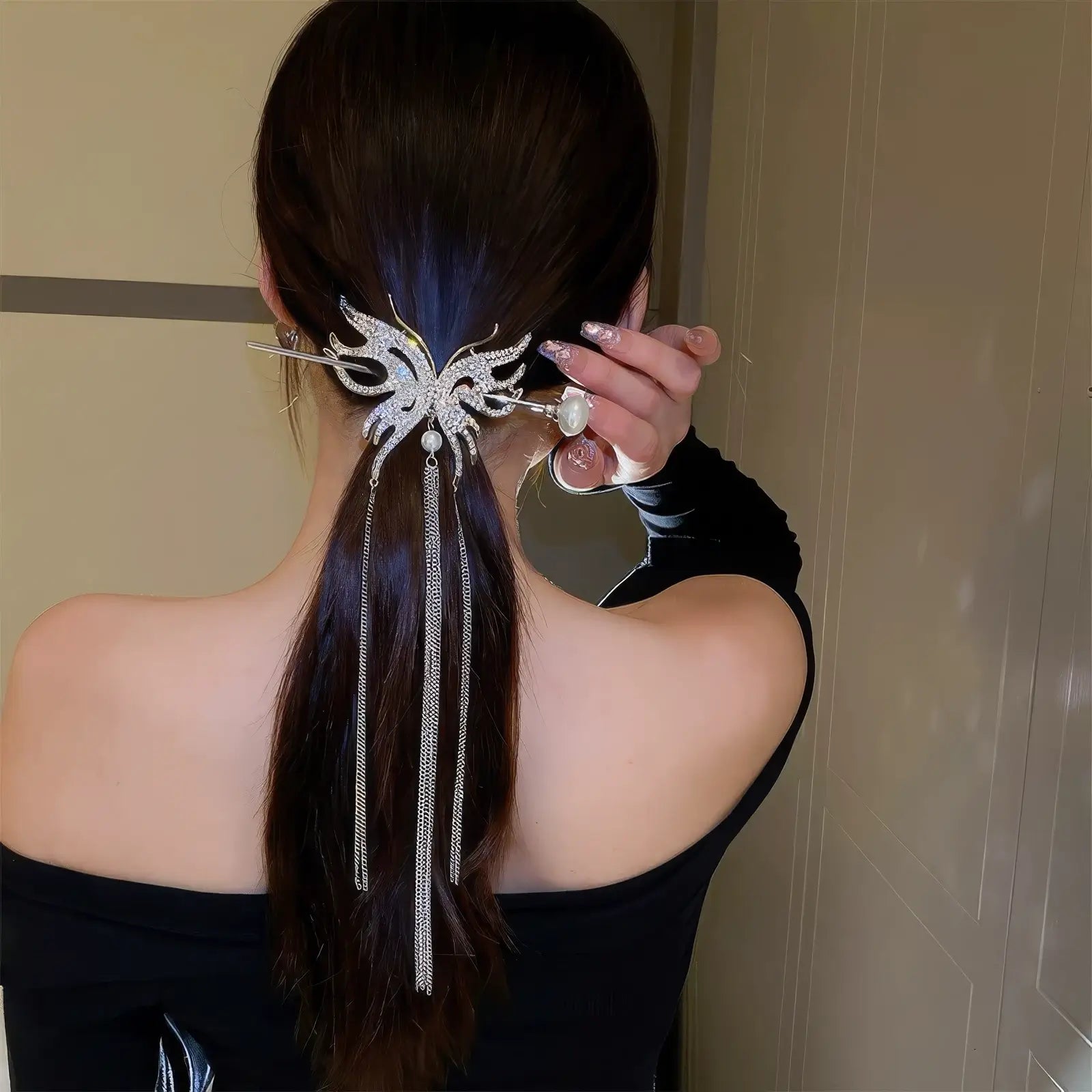 Shiny rhinestone butterfly hairpin with long metal tassels matched with pearl hair stick, fixed in low ponytail to display elegant swaying tassel effect.