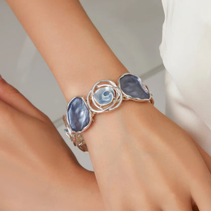 Rose - themed bracelet worn on wrist, showcasing stone and rose - motif details.