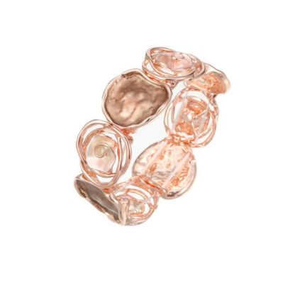 Rose - themed bracelet in rose gold, placed on a wooden surface.