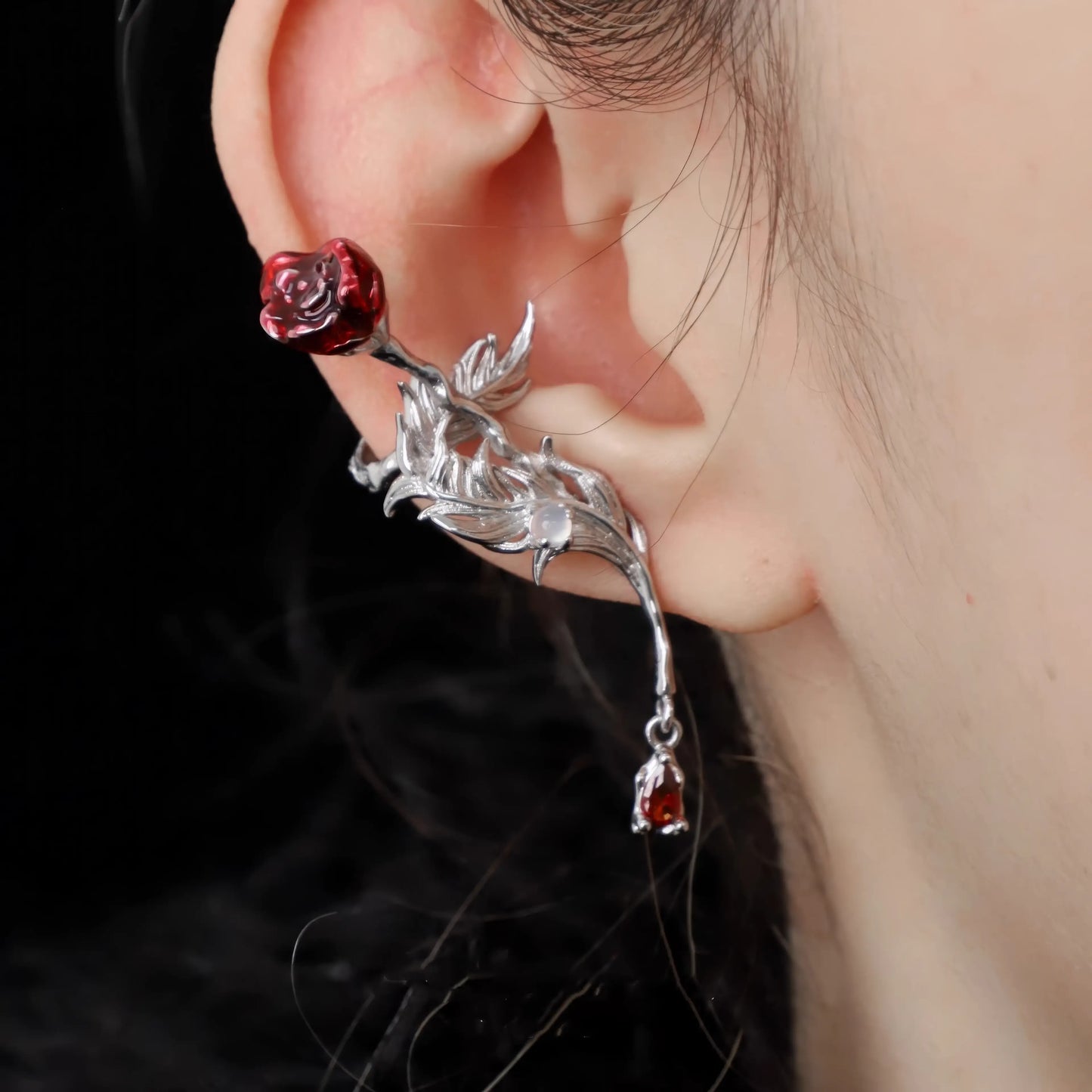 Rose feather ear cuff worn on ear, highlighting the intricate rose and feather design.