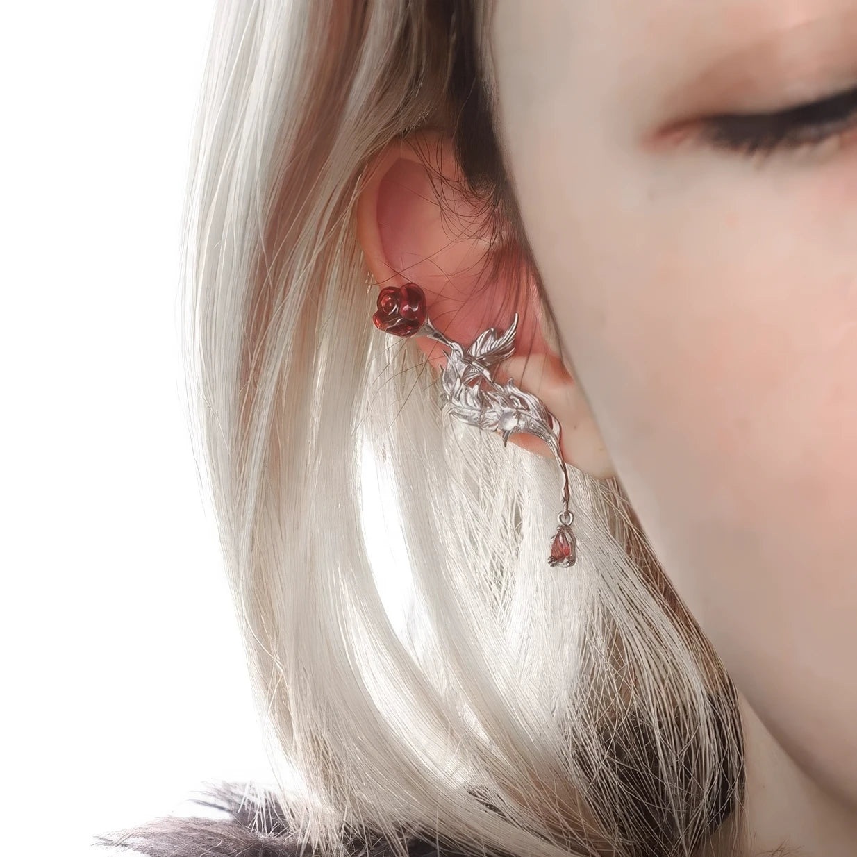 Rose feather ear cuff worn on ear, with light - colored hair in the background.