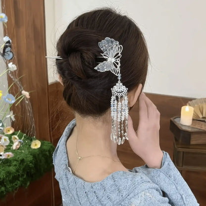 Close-up back view of the hairpin in a compact updo, focusing on the detailed butterfly design and dangling crystal strands.