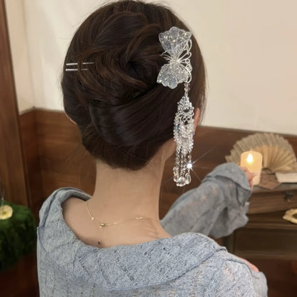  The silver butterfly hairpin worn in a neat low bun, with the long crystal tassel cascading down, highlighting its elegant drape.