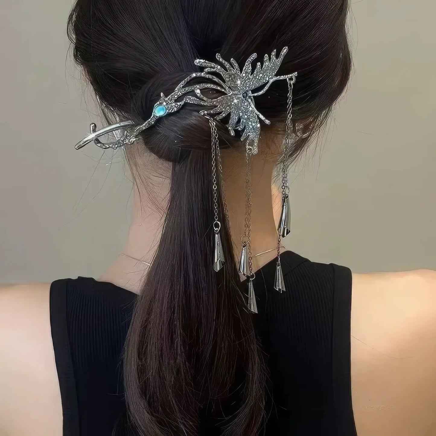 Silver crystal butterfly hair clip with dangling wind chime tassels, styled in a low ponytail to show its elegant, swinging effect.