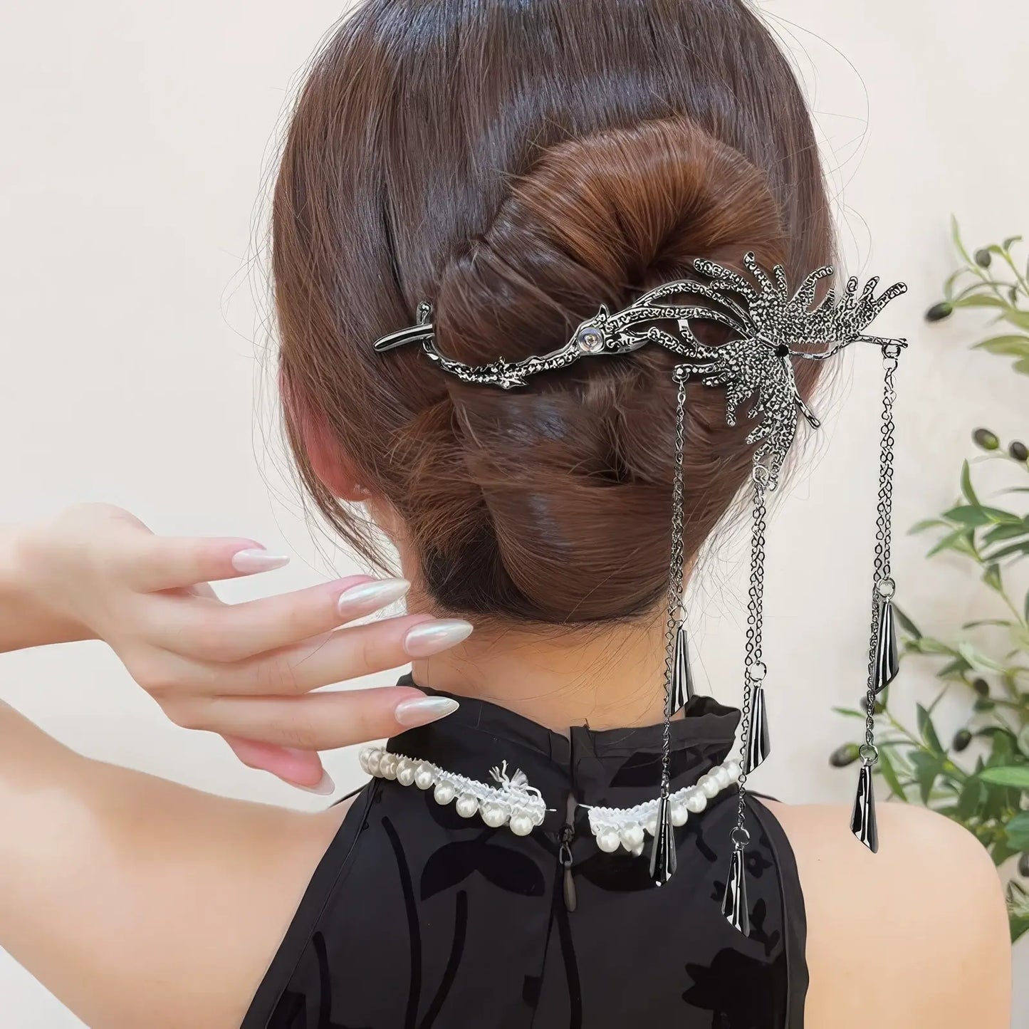 Silver butterfly hair clip decorating a formal updo, with the tassels hanging down to add movement and elegance.