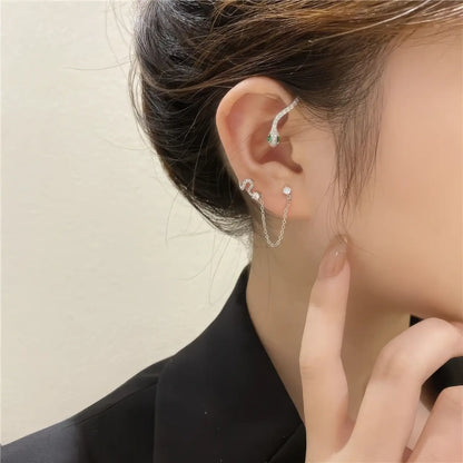  Silver needle diamond - inlaid snake - shaped ear cuff worn on the ear, with hand touching the ear, highlighting the sparkling diamond - inlaid snake design.