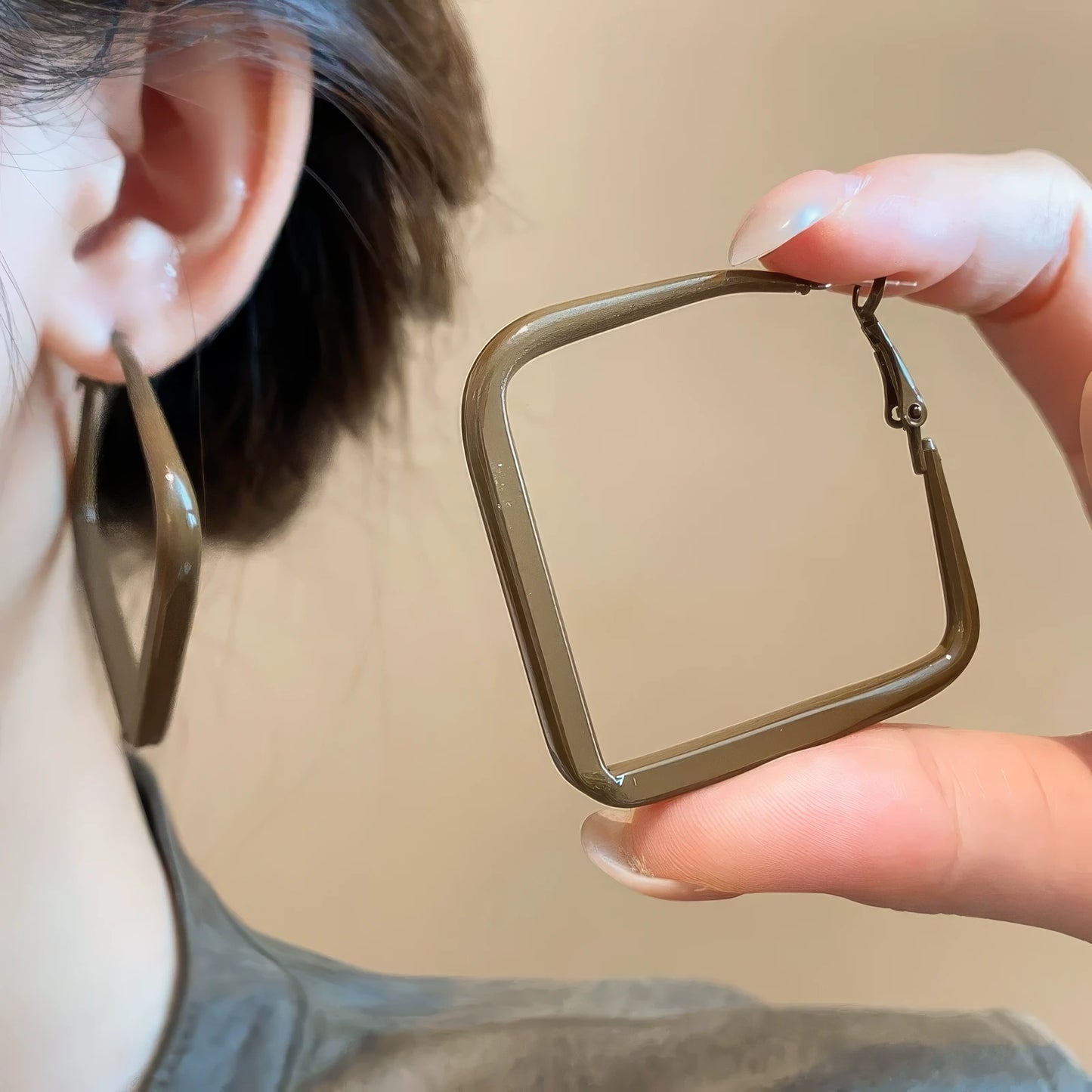 Pair of brown silver needle spray - painted square geometric earrings, hand - held and worn, showcasing the stylish, square look