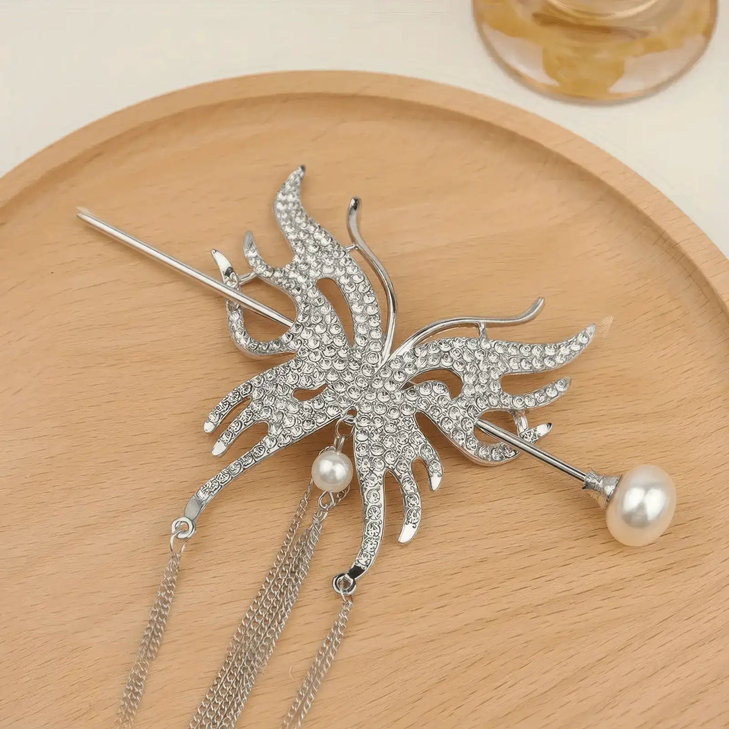 Gold-tone full rhinestone butterfly hair accessory set with long thin chain tassels, presented on wooden plate to highlight bright gold metal finish and crystal sparkle.