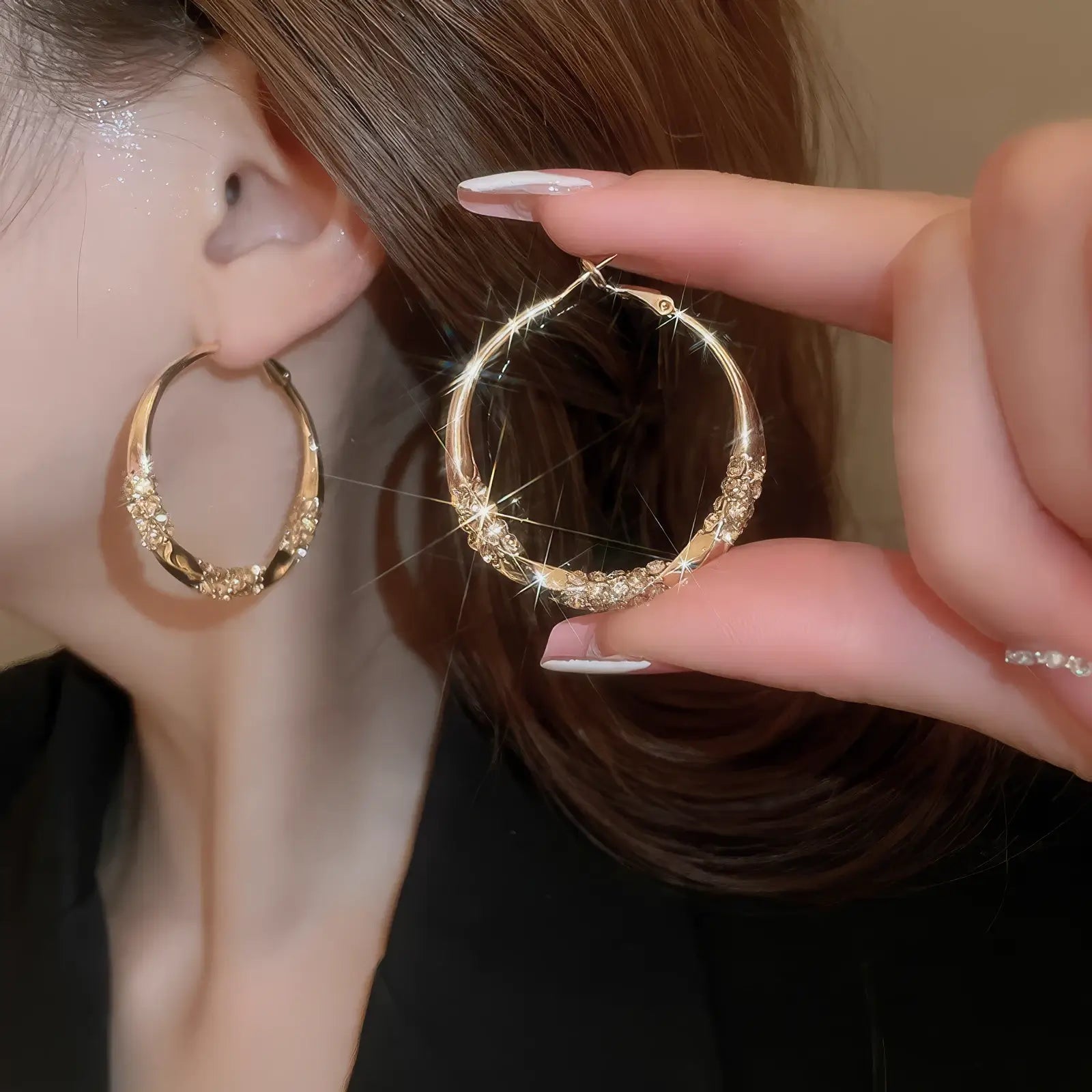 Gold twisted diamond - inlaid hoop earrings, hand - held and worn, showcasing the sparkling, curved design