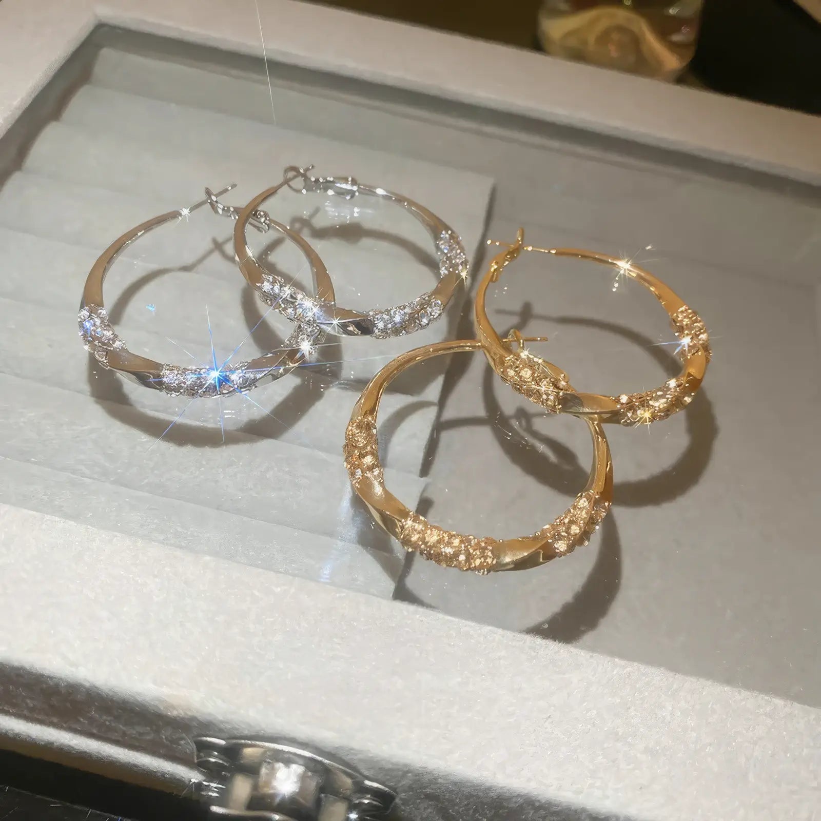  Mixed gold and silver twisted diamond - inlaid hoop earrings, displayed in a box, emphasizing the variety of metallic tones