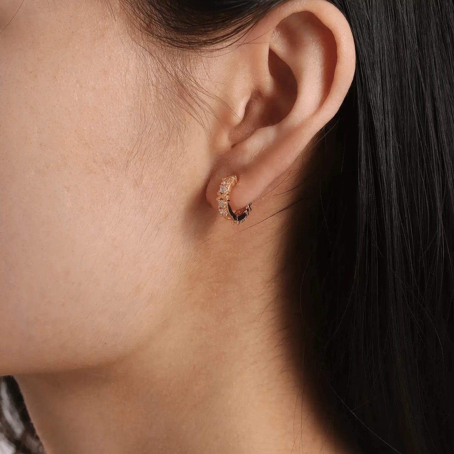 Gold zircon - inlaid cross hoop earring worn, showcasing the delicate and stylish look on the ear