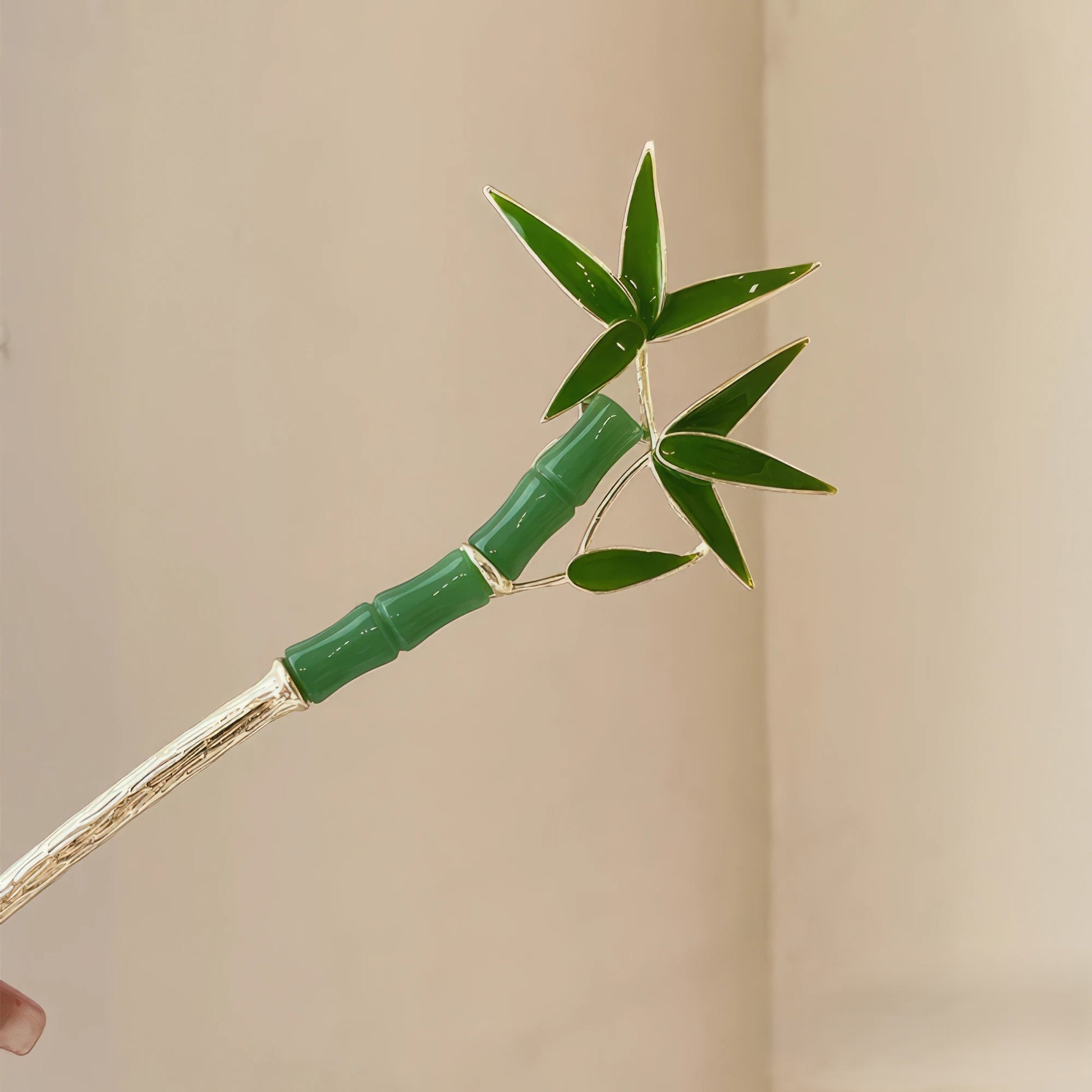 Green bamboo stalk hairpin with golden stem, closeup