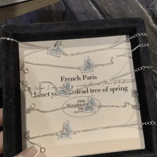 Blue butterfly - shaped silver bracelets in a black box with “French Paris” text