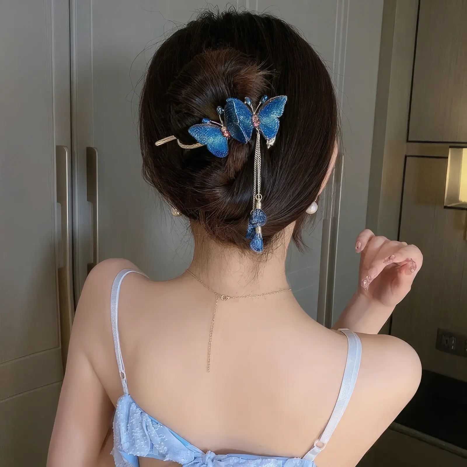 Blue butterfly twist clip worn in updo hairstyle (adjusting view)