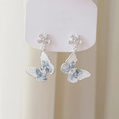 Blue crystal butterfly earrings attached to a card