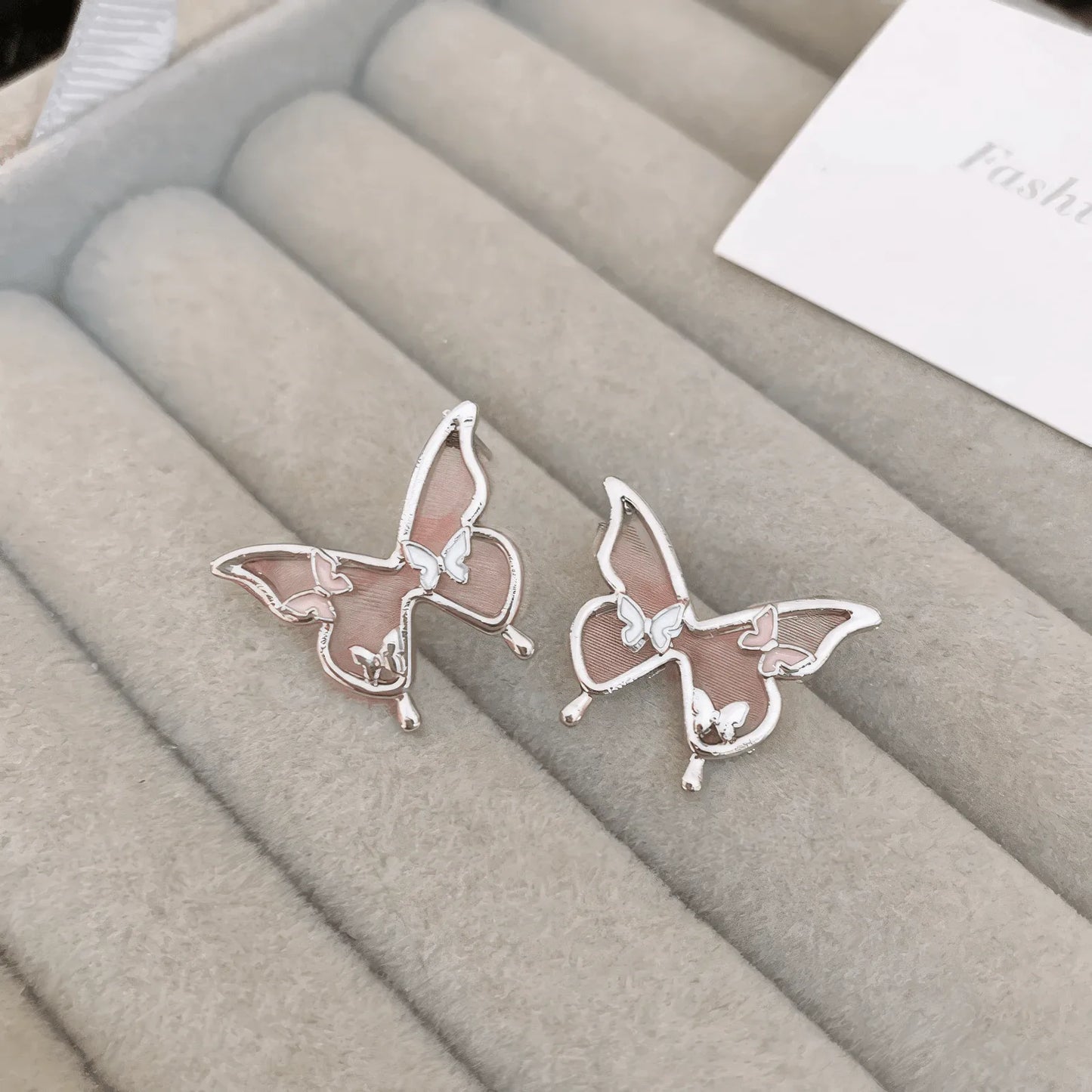 Blue crystal butterfly - outline earrings on a display tray