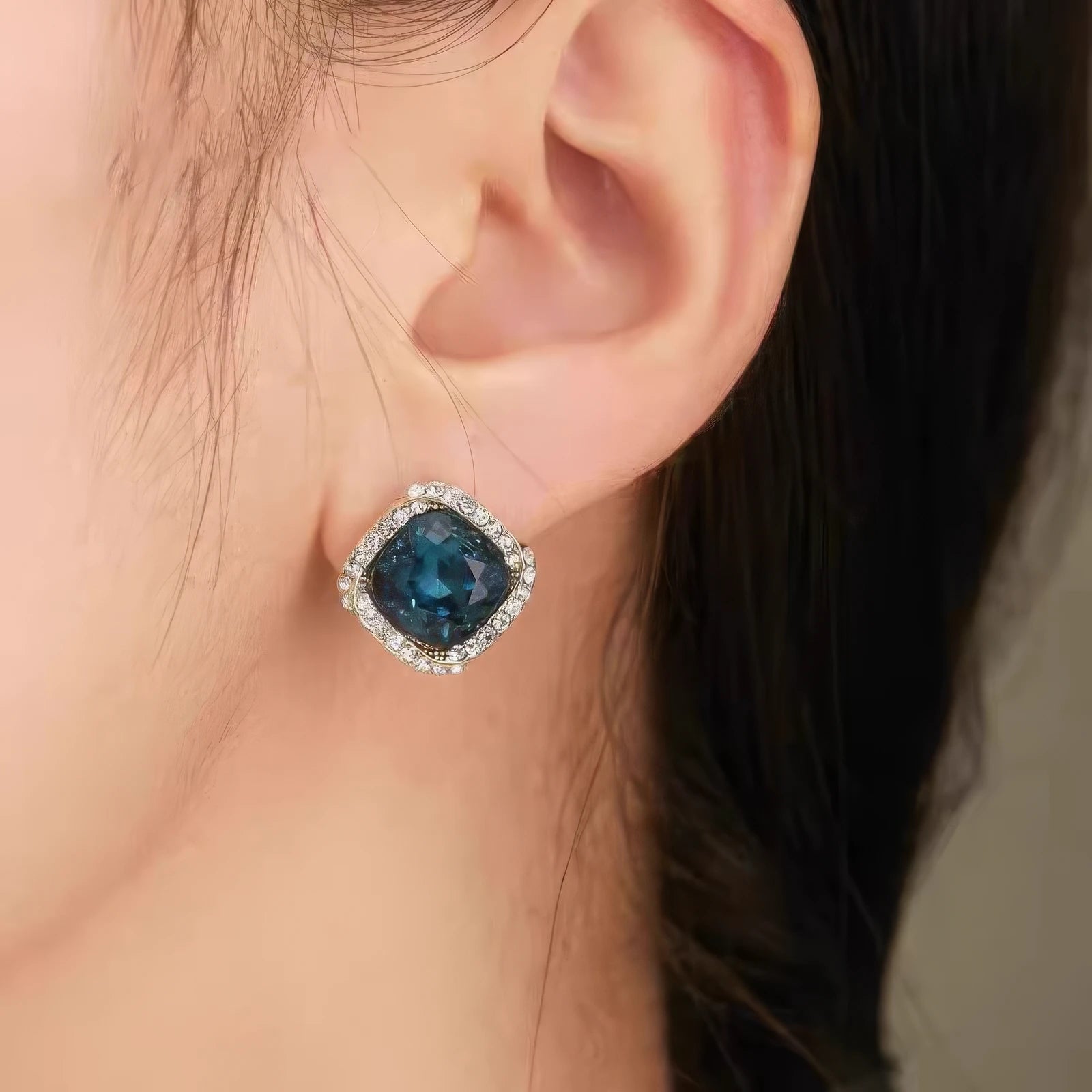 Blue diamond elegant earring worn on ear, emphasizing elegance